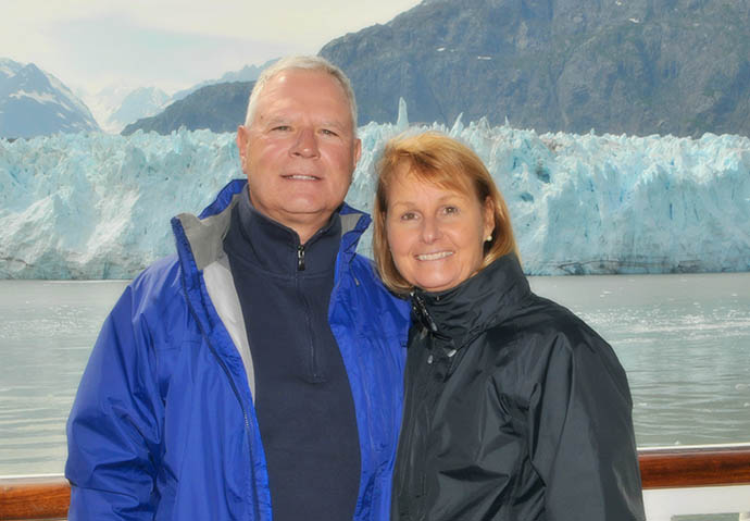 Laura and her husband pose in front of a glacier. 